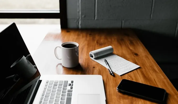 Mesa com laptop e caderno de anotações